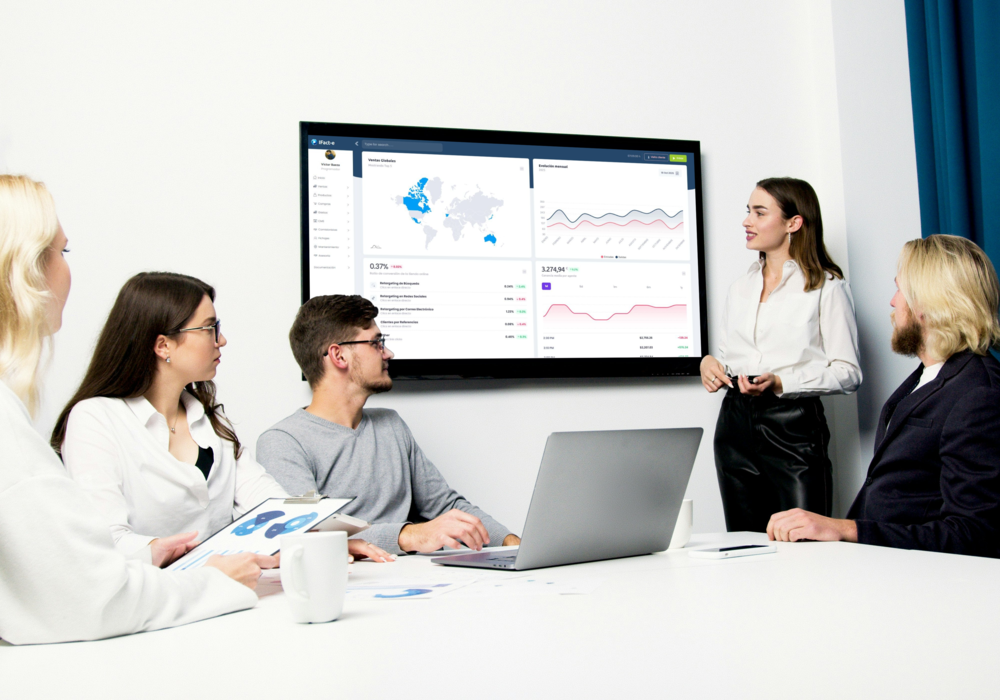 Reunión de trabajo con dashboard del software het en la pantalla de presentación de la sala.